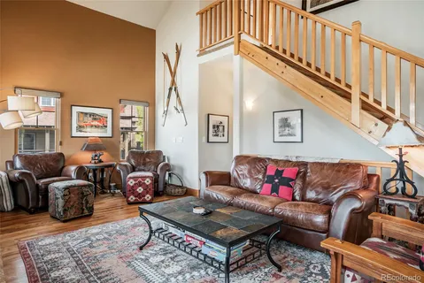 a living room with furniture a couch and dresser with wooden floor