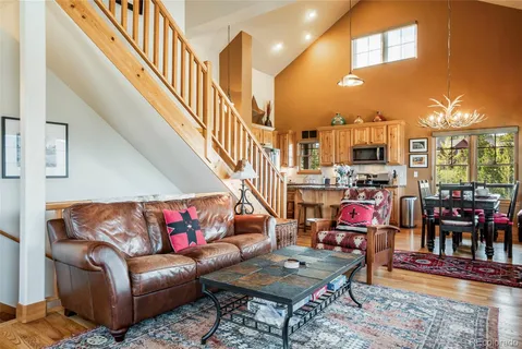 a living room with furniture kitchen view and a wooden floor