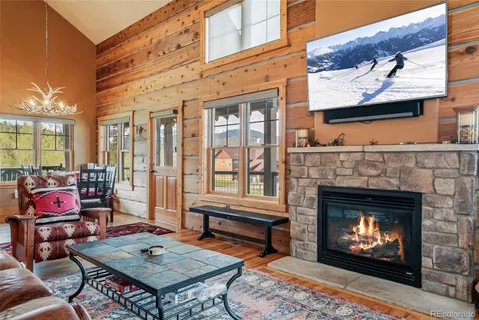 a living room with furniture a rug a fireplace and windows