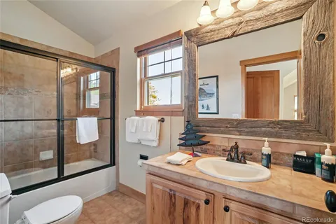 a bathroom with a sink vanity mirror and tub