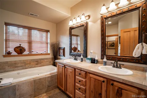 a bathroom with a granite countertop sink mirror and a bathtub