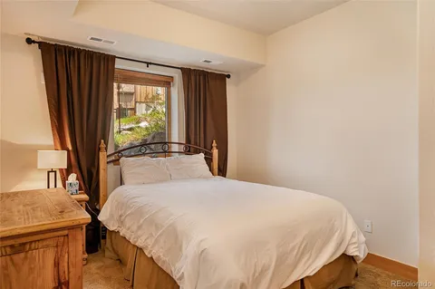 a large bed sitting in a bedroom next to a window