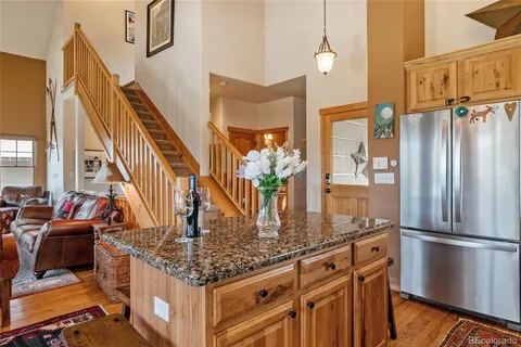 a kitchen with stainless steel appliances granite countertop a refrigerator a stove and a sink