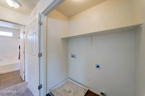 an empty room with ceiling fan and windows