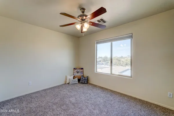 an empty room with closet and a chandelier fan