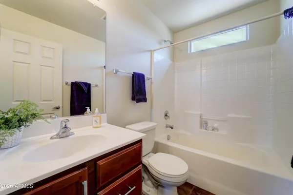 an empty room with chandelier fan and windows