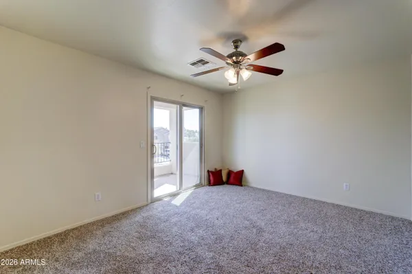 an empty room with closet and a chandelier fan