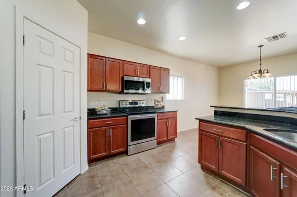 a kitchen with stainless steel appliances granite countertop a stove a sink and a microwave