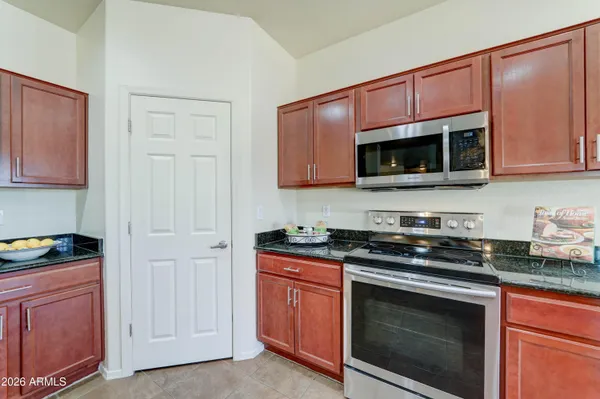 a kitchen with granite countertop a stove microwave and cabinets