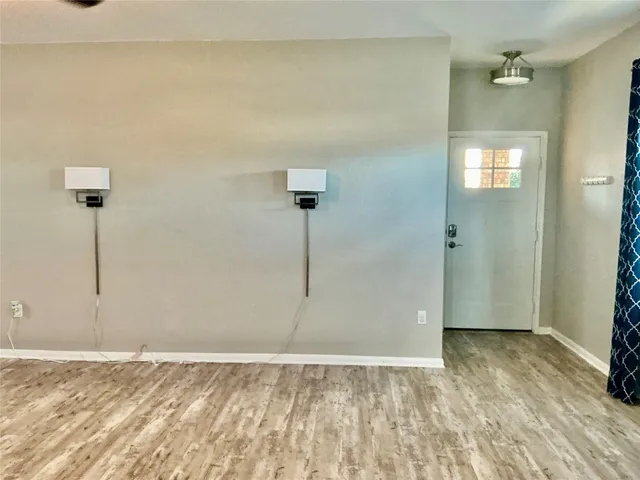 a view of a livingroom with a flat screen tv wooden floor and a ceiling fan