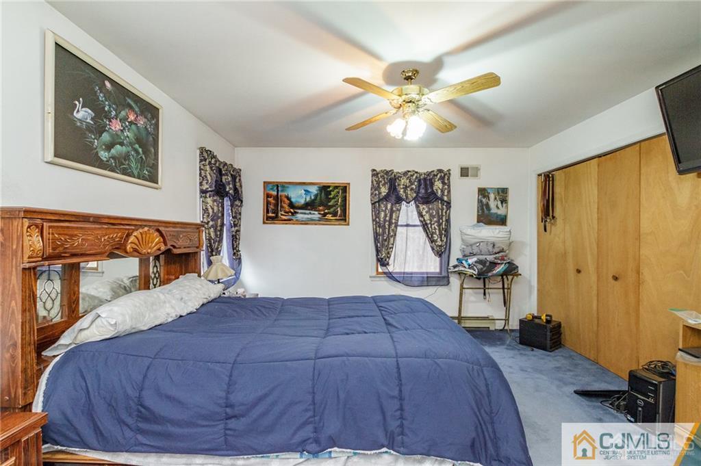 434 Burke Road Jackson, NJ 08527 - Photo 20 of 27 a bedroom with a bed and a chandelier