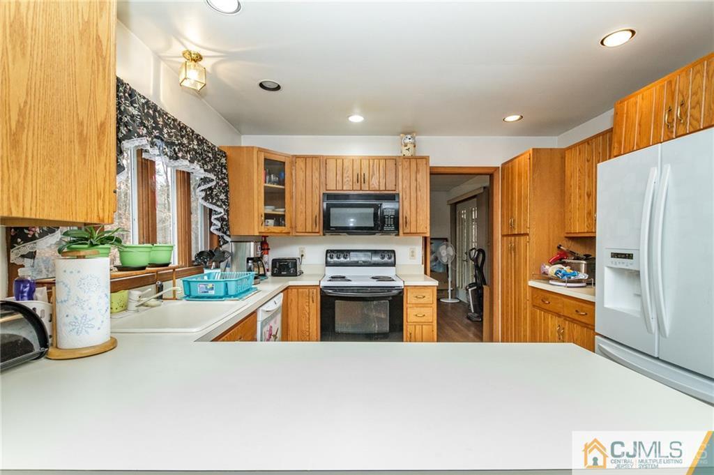 434 Burke Road Jackson, NJ 08527 - Photo 8 of 27 a kitchen with stainless steel appliances granite countertop a refrigerator a stove and a sink with wooden floor
