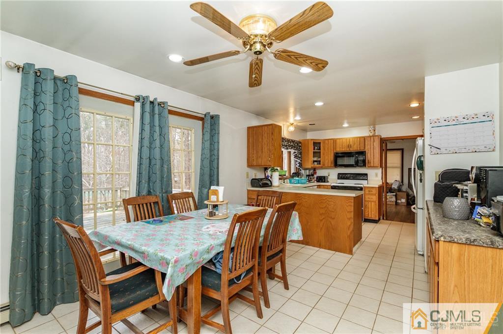 434 Burke Road Jackson, NJ 08527 - Photo 10 of 27 a dining room with stainless steel appliances kitchen island granite countertop a table chairs and a refrigerator