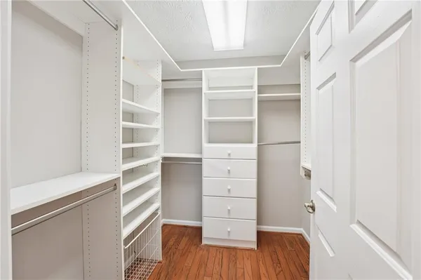 a view of walk in closet with empty racks