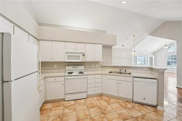 a kitchen with a sink stove and white cabinets