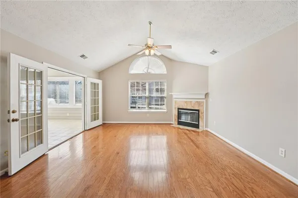 a view of a livingroom with wooden floor fireplace and windows