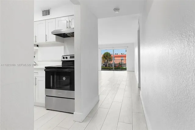 a kitchen with white cabinets and appliances