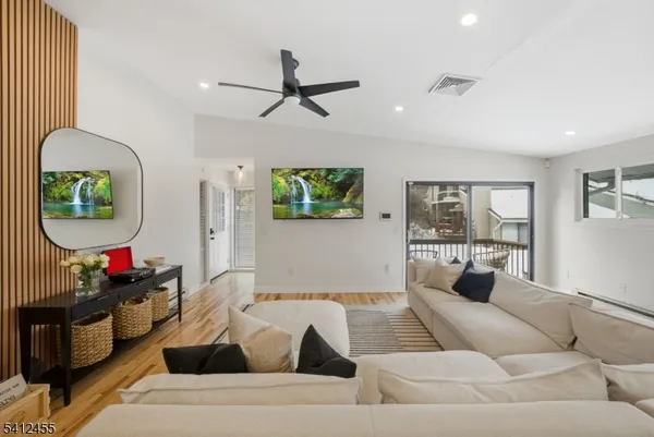 a living room with furniture and a wooden floor