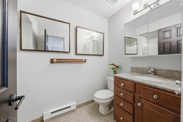 a bathroom with a toilet a sink and mirror