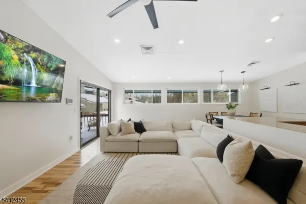 a living room with furniture large window and wooden floor