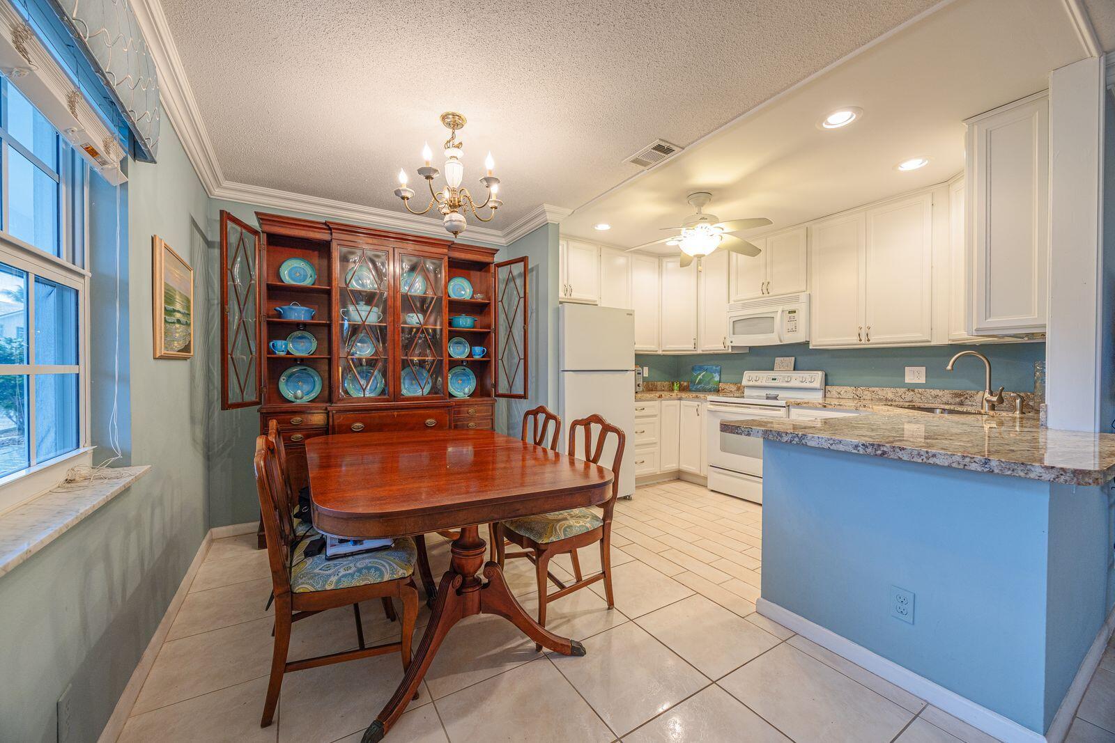 5505 North Ocean Boulevard, Unit 8108 Ocean Ridge, FL 33435 - Photo 3 of 22 a kitchen with stainless steel appliances granite countertop a stove top oven a sink dishwasher and a refrigerator with wooden cabinets
