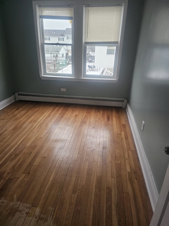 52 Fuller Street, Unit 1 Everett, MA 02149 - Photo 5 of 10 an empty room with wooden floor and windows