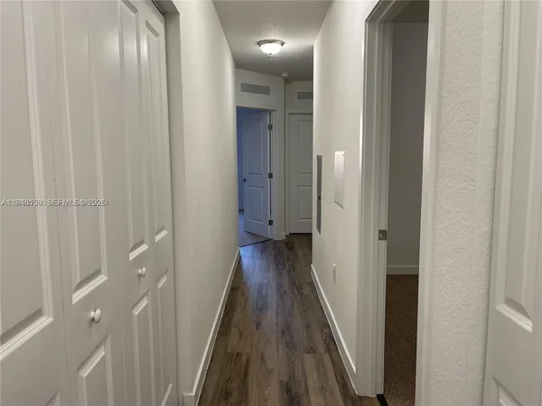 a view of a hallway with wooden floor