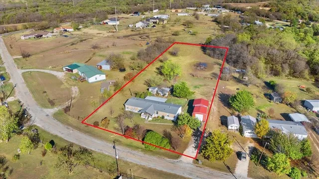 an aerial view of a house a yard and mountain