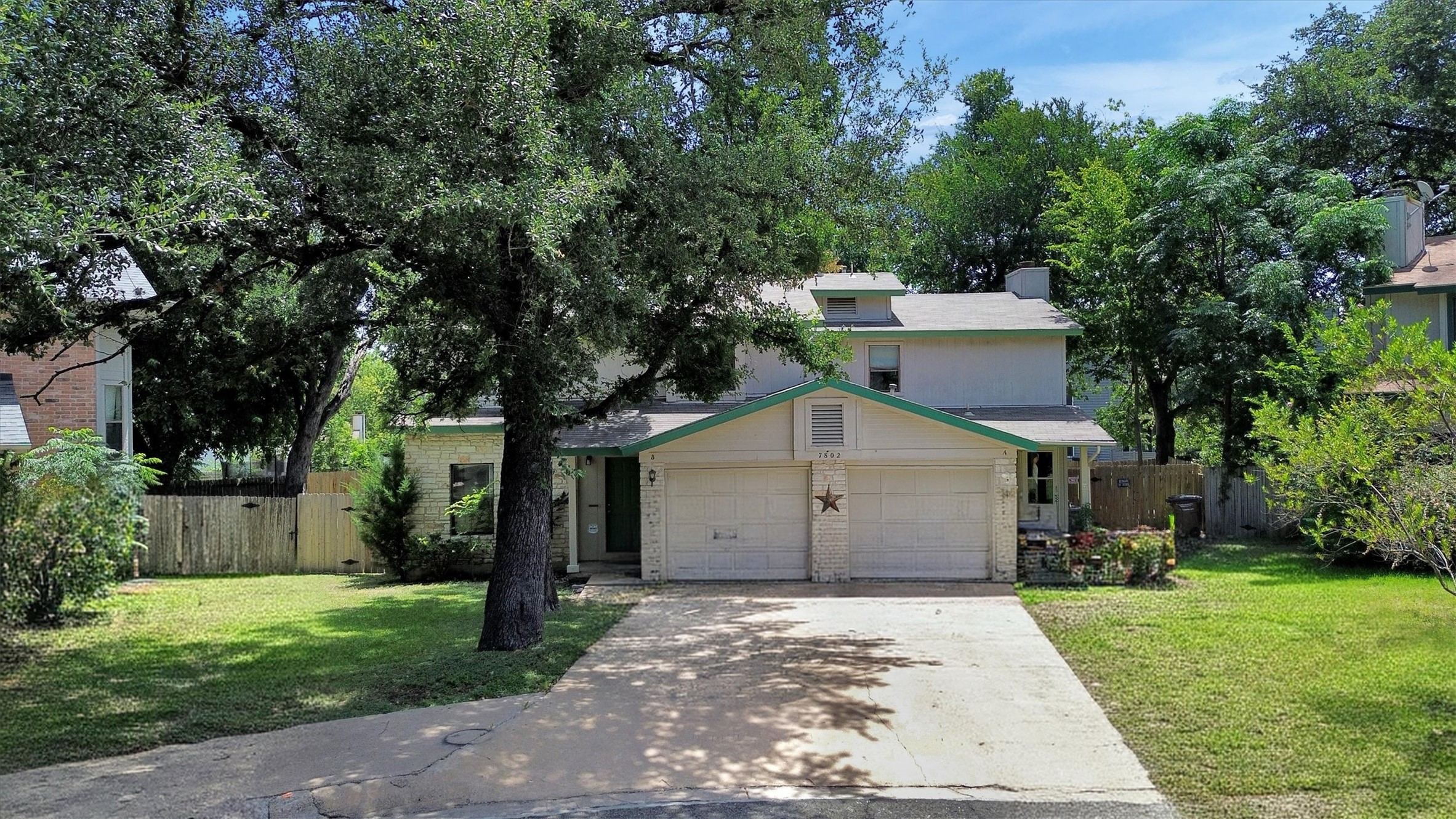 7802 Topawa Cove, Unit B Austin, TX 78729 - Photo 29 of 32 Mature trees shade this inviting front facade, offering privacy and curb appeal.