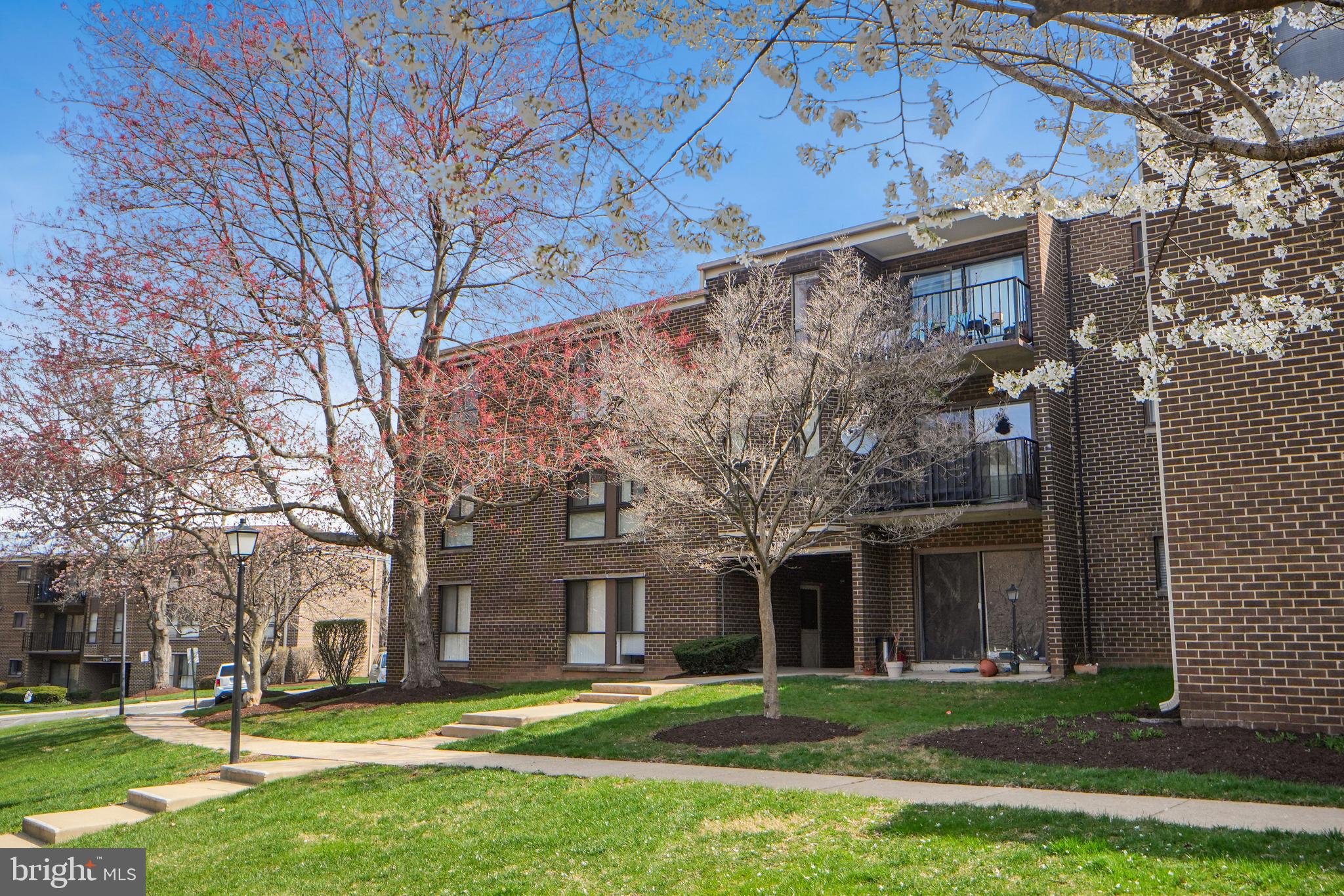 17805 Buehler Road, Unit 3 Olney, MD 20832 - Photo 29 of 30 a brick building with a big yard and large trees