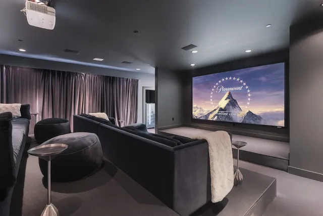 a room with furniture projector and screen