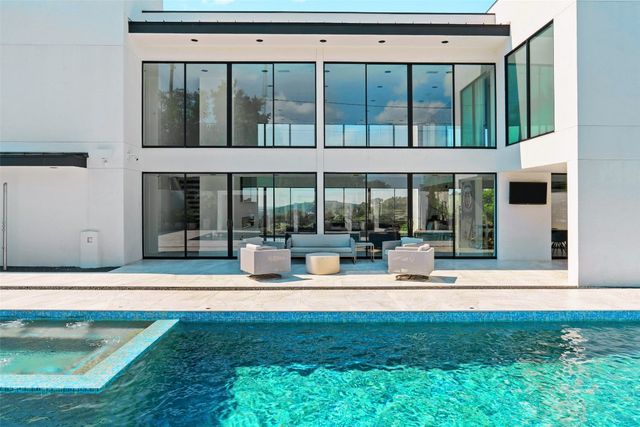 a view of a house with backyard sitting area and swimming pool