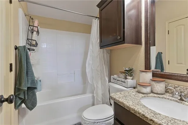 a bathroom with a granite countertop sink toilet and shower