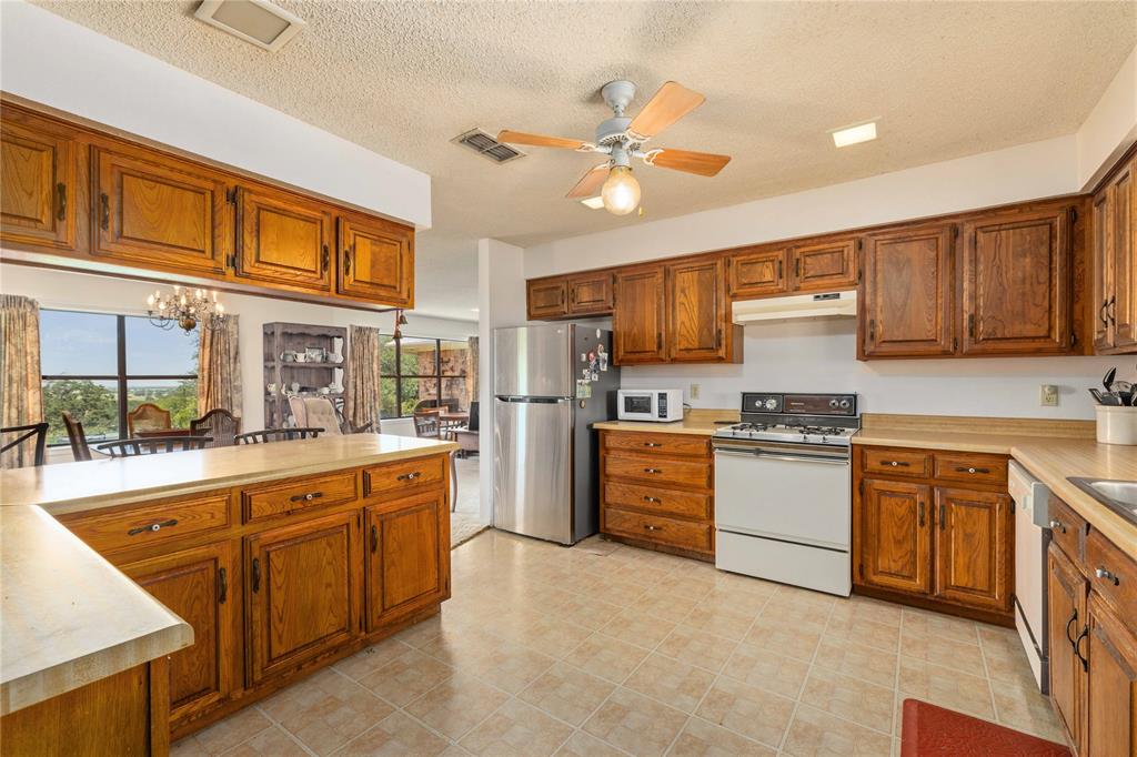 3718 Highway 36 Rising Star, TX 76471 - Photo 23 of 36 a kitchen with stainless steel appliances granite countertop a stove sink and cabinets
