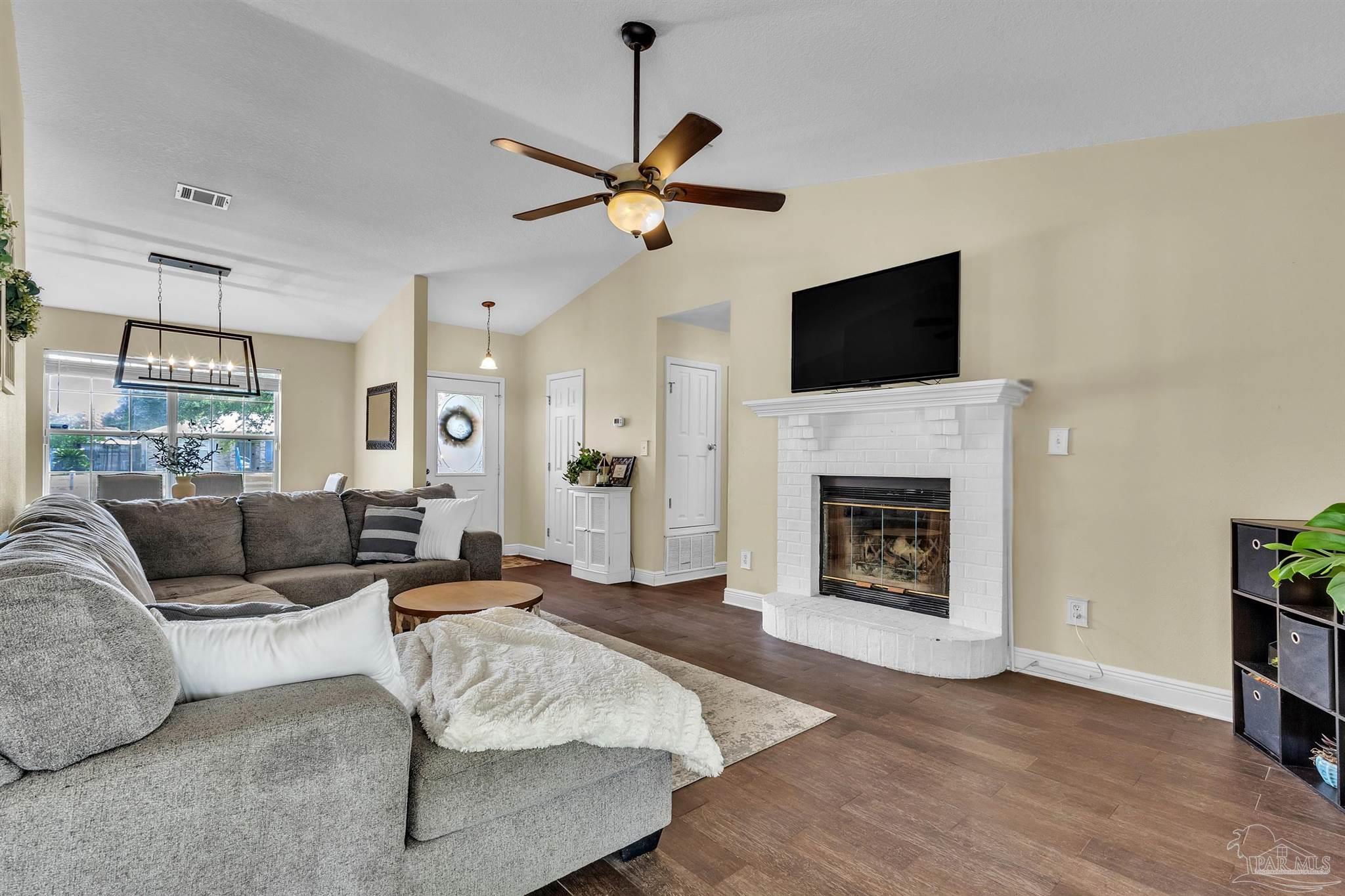 4321 Ridgeland Drive Pace, FL 32571 - Photo 3 of 36 a living room with furniture a fireplace and a flat screen tv