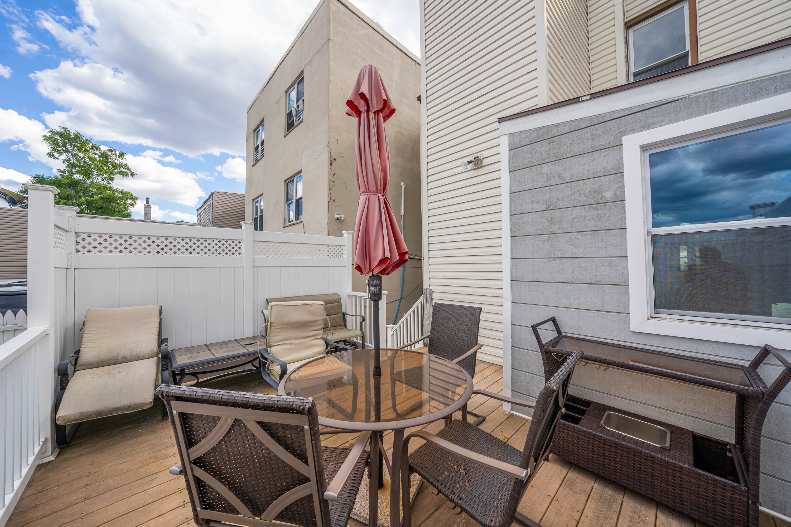 600 67th Street, Unit 1 & LL West New York, NJ 07093 - Photo 19 of 29 a view of a patio with table and chairs with wooden floor and fence