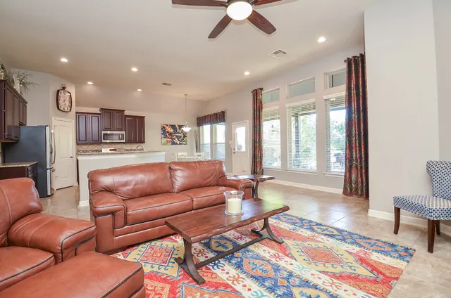 a living room with furniture ceiling fan and a rug