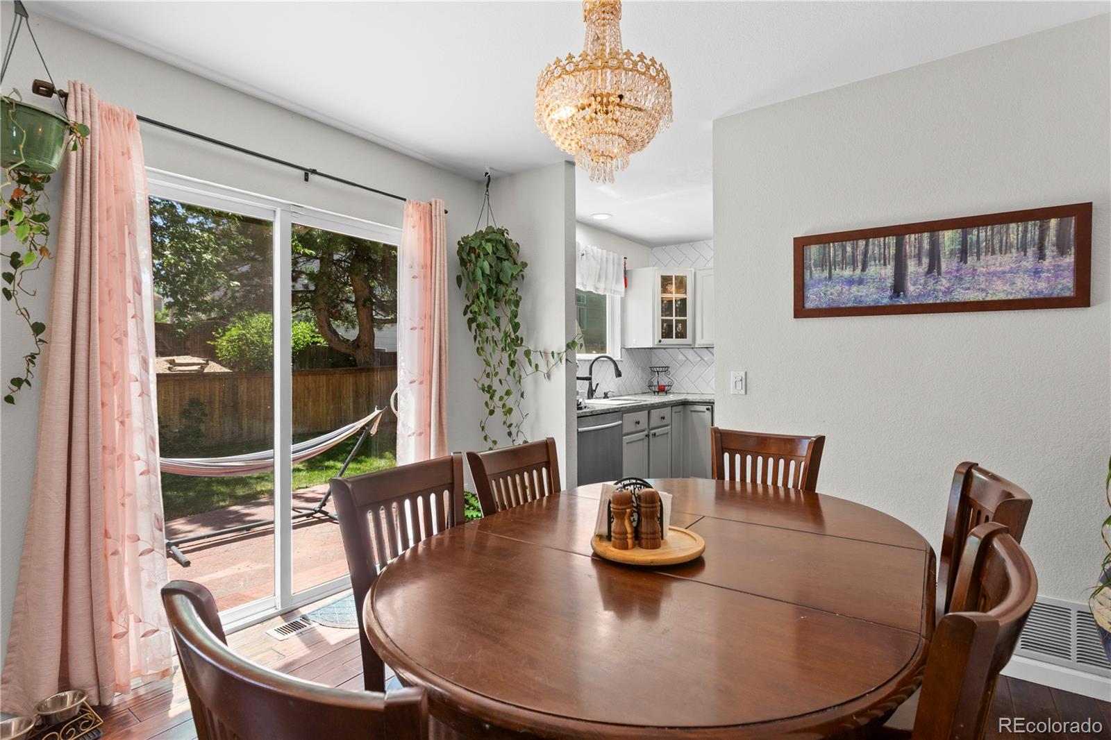 2212 Hyacinth Road Littleton, CO 80129 - Photo 12 of 44 a dining room with furniture a window and kitchen view
