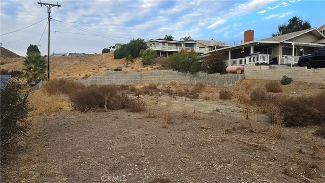 a view of a dirt road with a building in the background