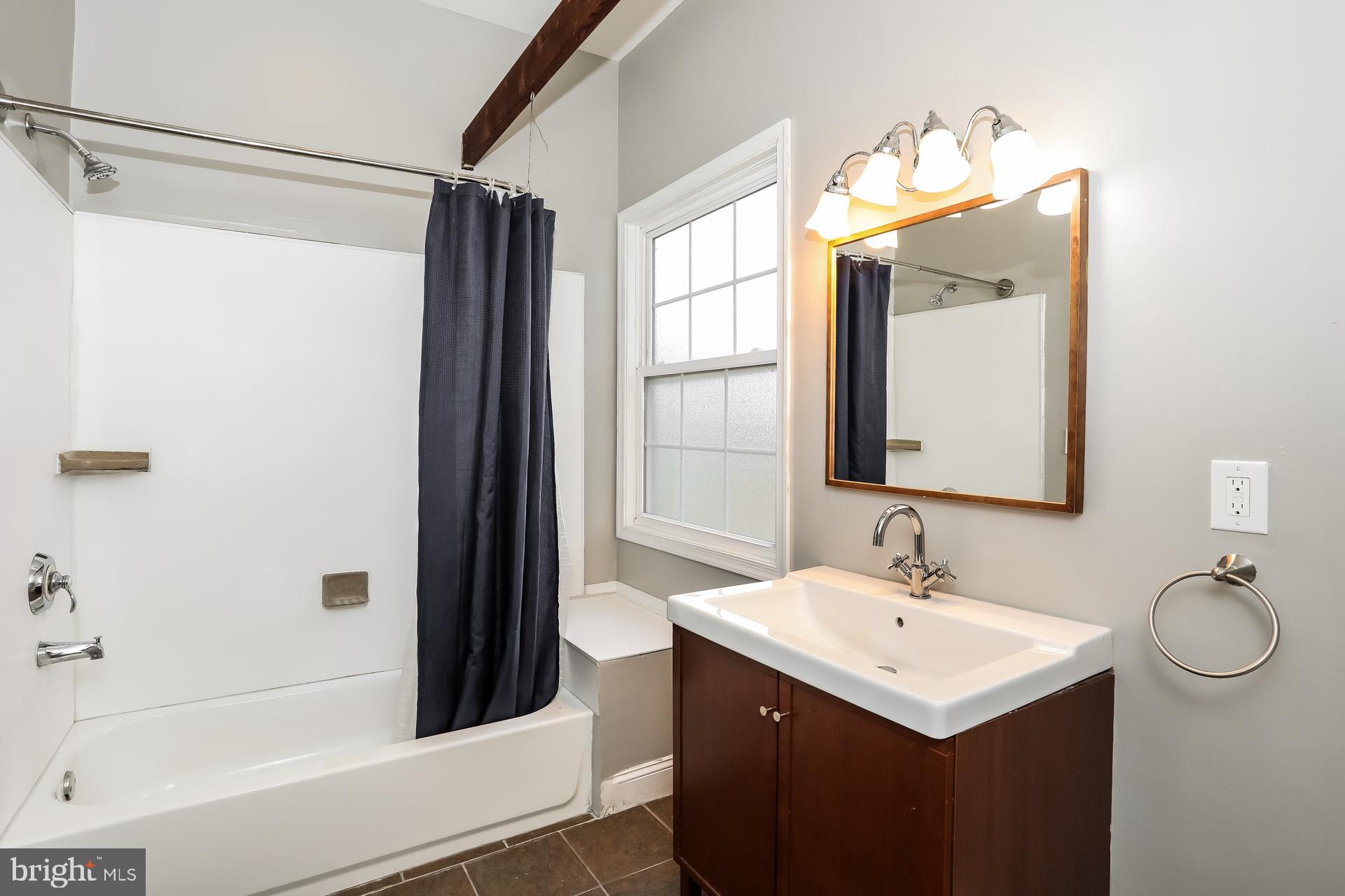 6207 Eastern Parkway Baltimore, MD 21206 - Photo 13 of 15 a bathroom with a sink a mirror and a bathtub