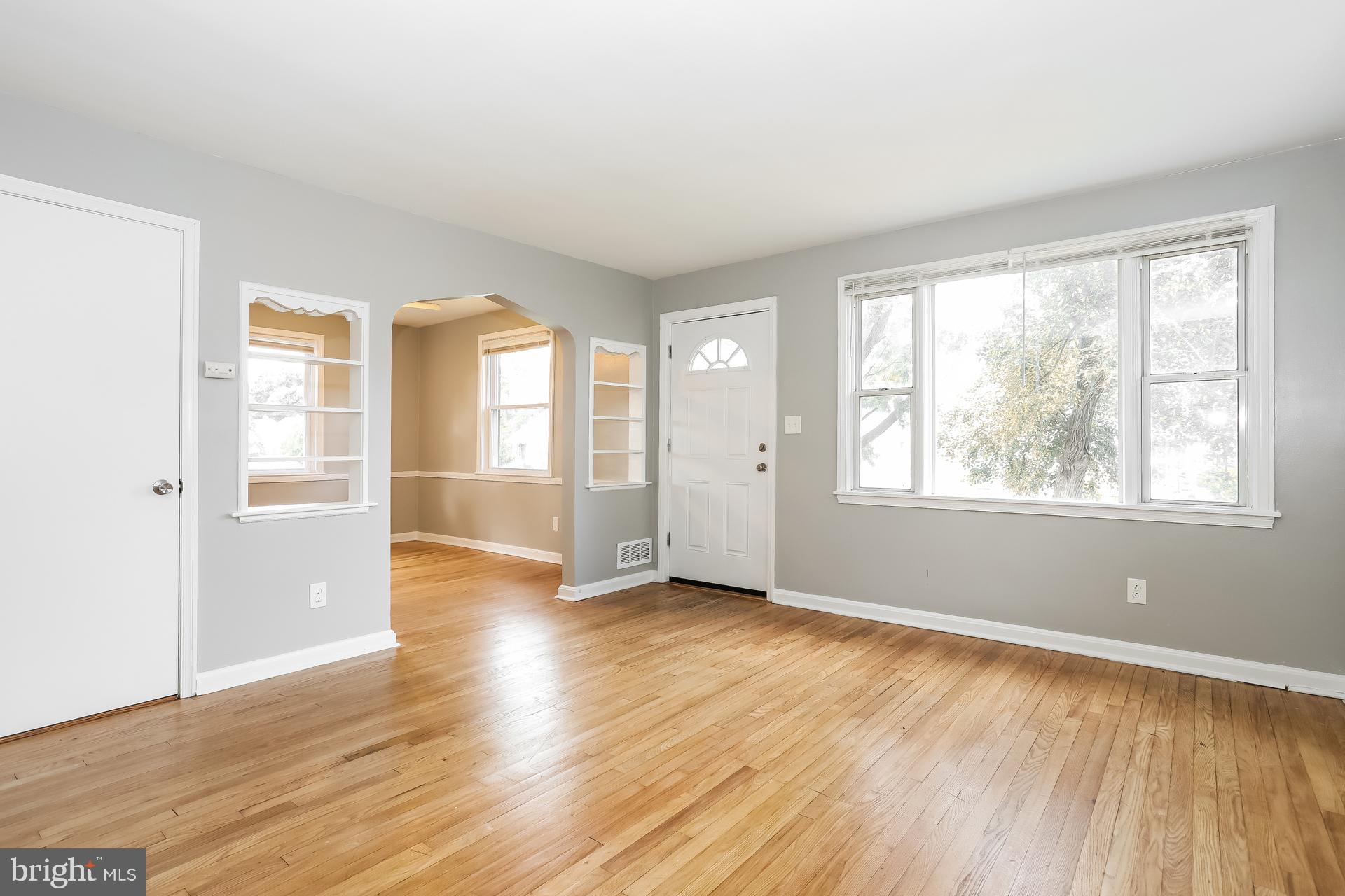 6207 Eastern Parkway Baltimore, MD 21206 - Photo 2 of 15 an empty room with wooden floor and windows