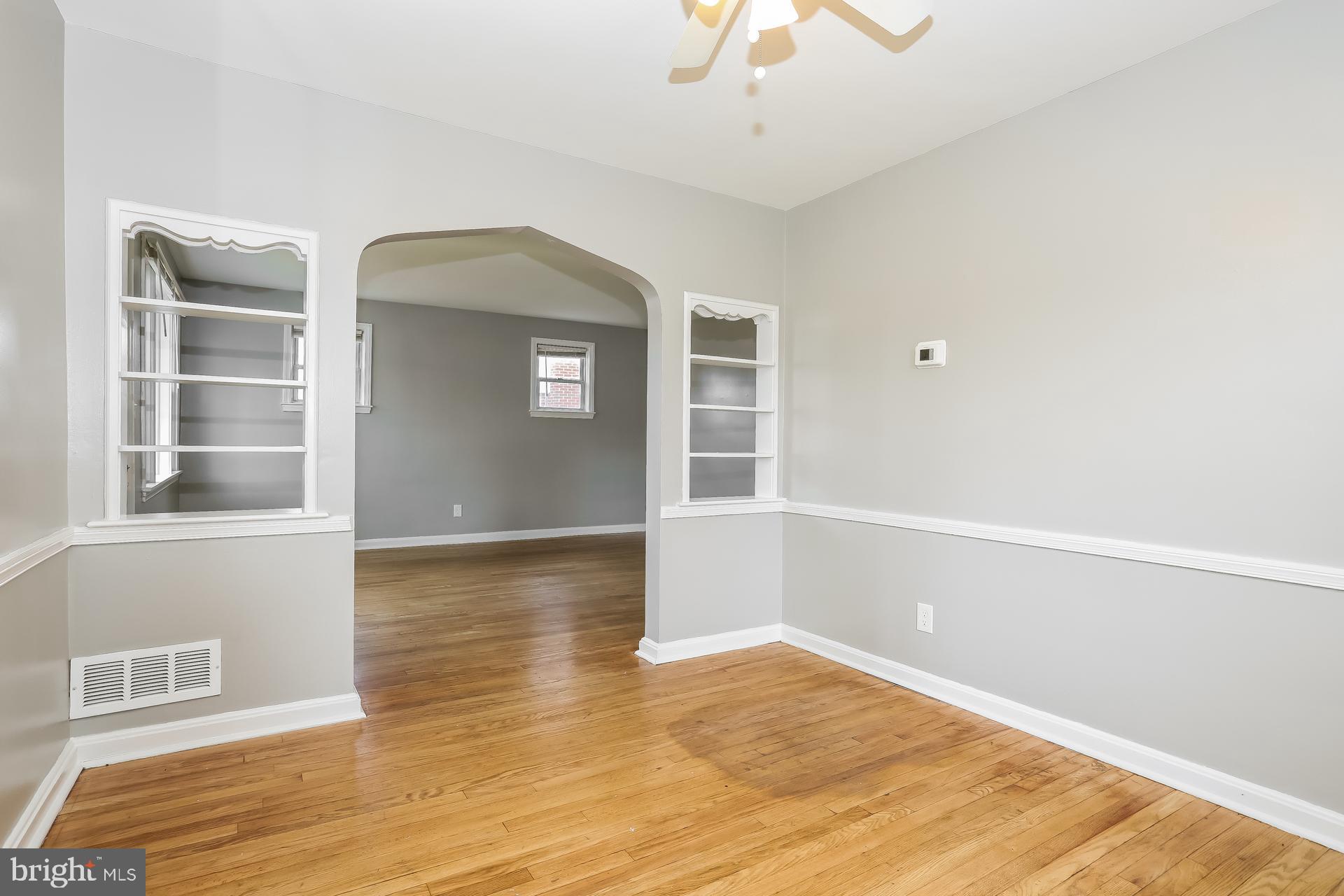 6207 Eastern Parkway Baltimore, MD 21206 - Photo 3 of 15 an empty room with wooden floor cabinet and windows