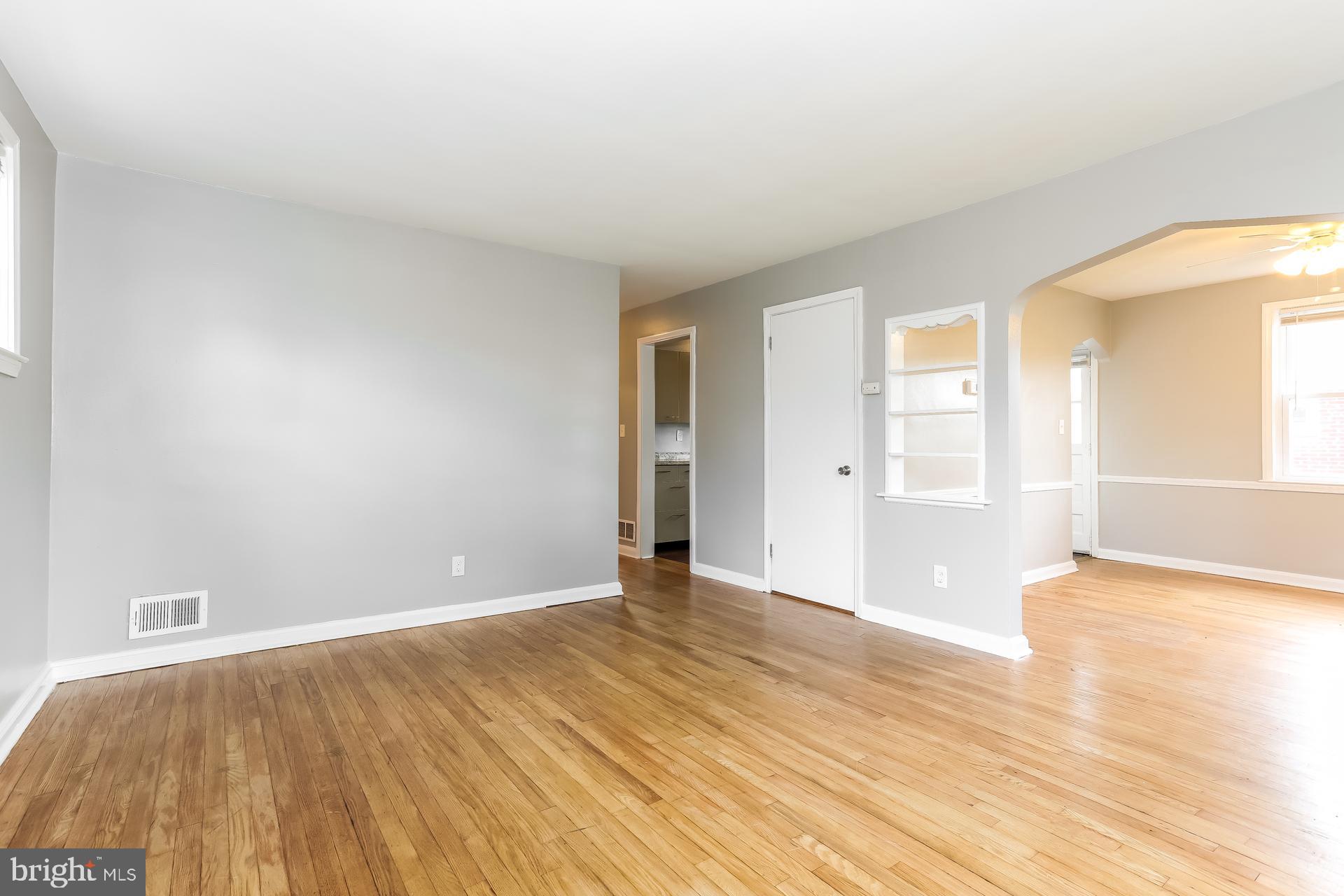 6207 Eastern Parkway Baltimore, MD 21206 - Photo 4 of 15 an empty room with wooden floor and windows