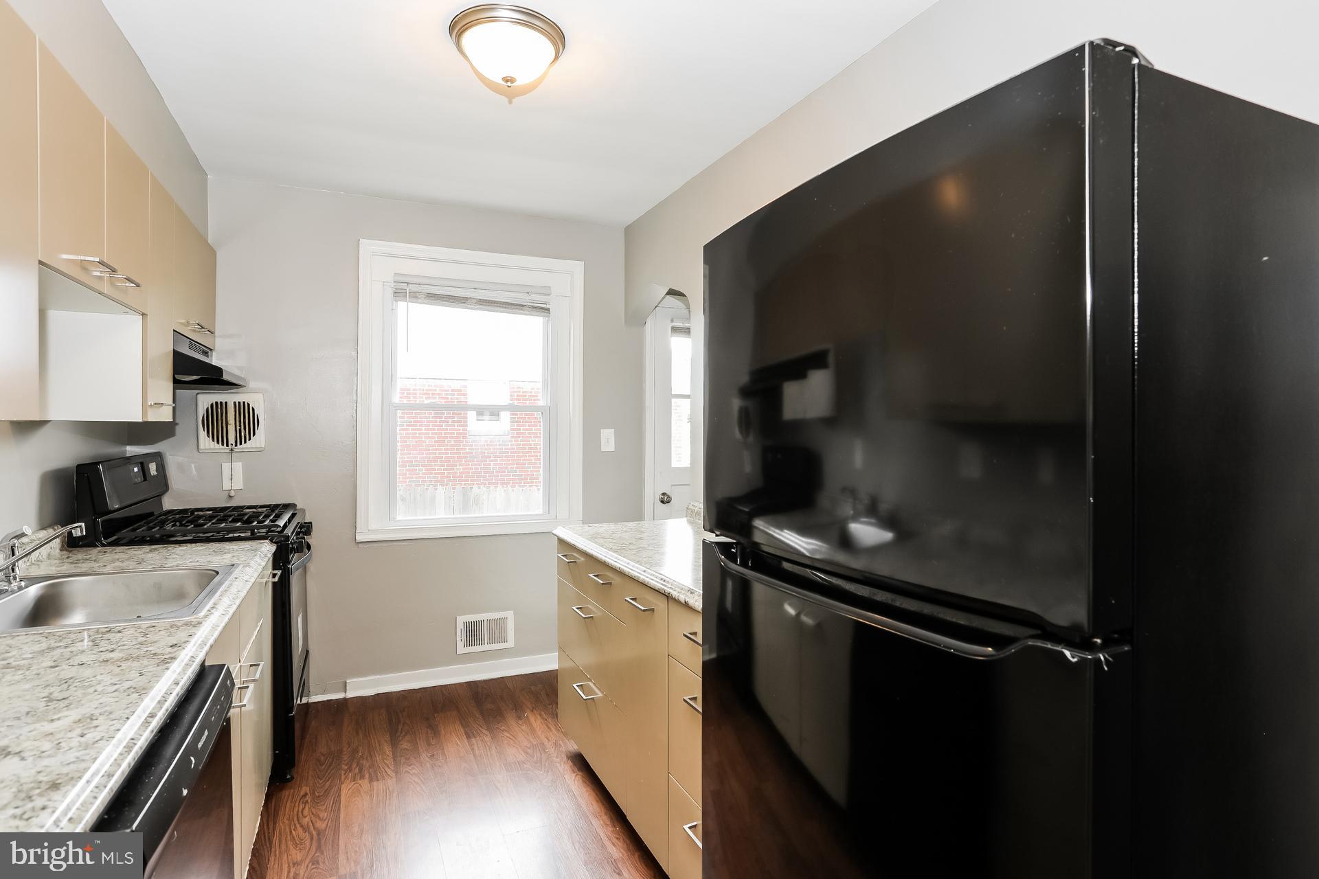 6207 Eastern Parkway Baltimore, MD 21206 - Photo 7 of 15 a kitchen with a refrigerator stove and sink