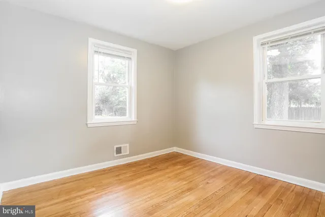a view of a room with wooden floor and windows