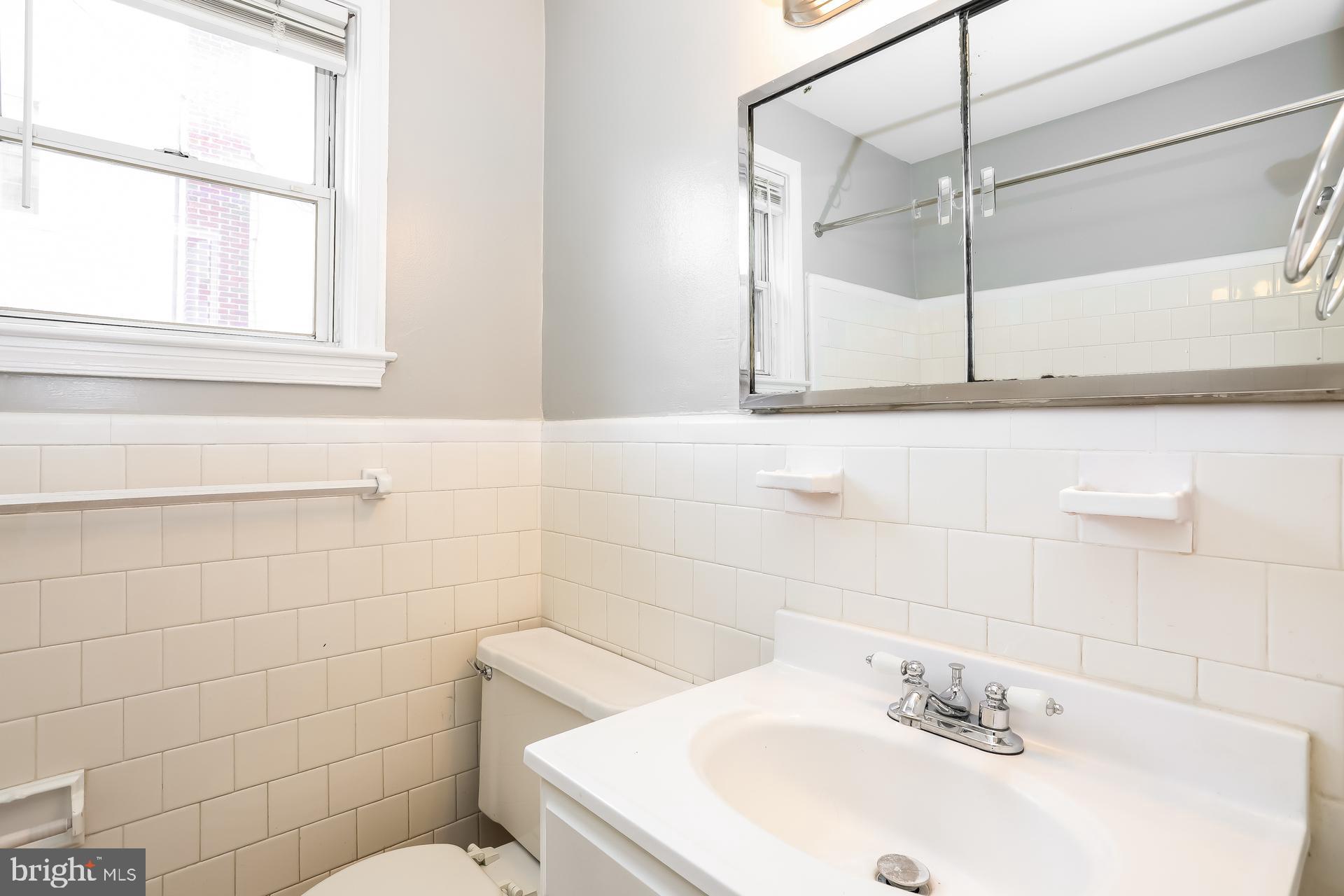 6207 Eastern Parkway Baltimore, MD 21206 - Photo 9 of 15 a bathroom with a sink a toilet and shower