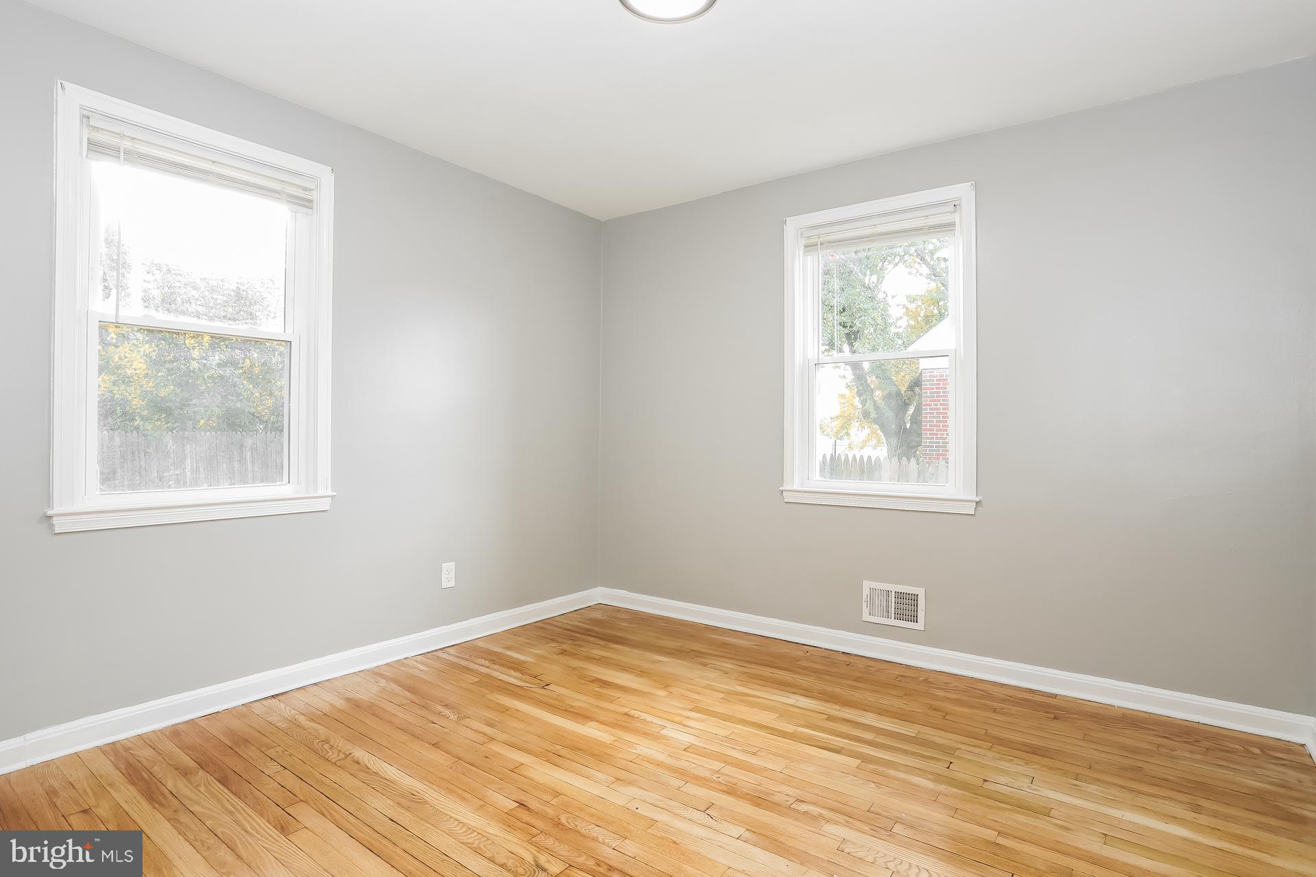 6207 Eastern Parkway Baltimore, MD 21206 - Photo 10 of 15 a view of an empty room with wooden floor and a window