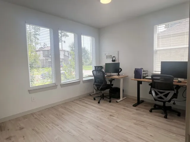 a view of a workspace with furniture and a window