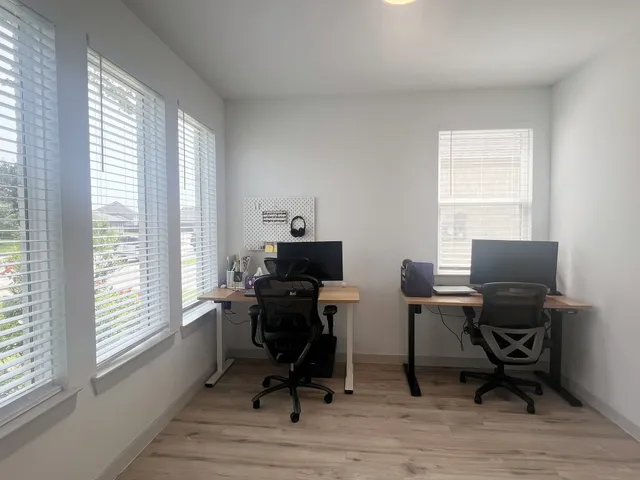 a view of a workspace with furniture and a window