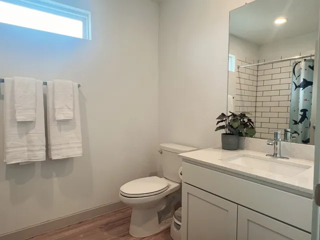a bathroom with a sink a toilet and shower
